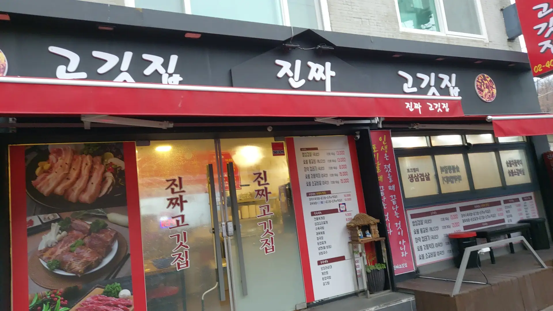 진짜 고깃집 실제 건물 외관과 검정색 간판, 빨간 어닝